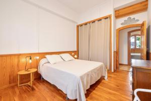 a bedroom with a white bed and a table at Ca la Crish in Horta de San Joan