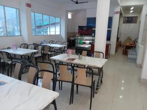 a restaurant with tables and chairs in a room at Swayambhu Hotel in Rudraprayāg