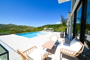 a patio with a table and chairs and a swimming pool at Villa 30 Luxury Place Vlore in Fshati i Ri