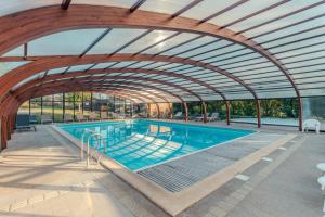 a large swimming pool with an arched ceiling at Camping maeva Escapades Domaine de la Vingeanne in Longeau