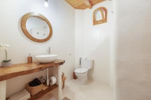 a bathroom with a sink and a toilet and a mirror at Ca la Crish in Horta de San Joan