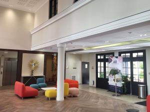 a lobby with colorful chairs and tables in a building at Adagio Serris Val d'Europe in Serris