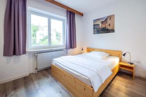 a bedroom with a bed and a window at Apartment-Haus Gundelfinger in Gräfenberg