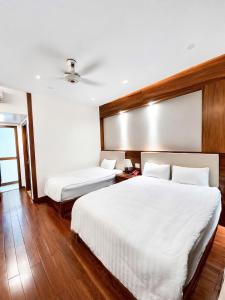 a bedroom with two beds and a ceiling at Pandora Hotel Cần Thơ in Can Tho