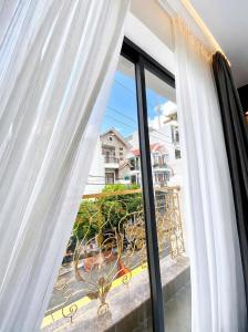 a room with a window with white curtains at Pandora Hotel Cần Thơ in Can Tho