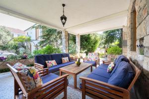 a patio with chairs and couches and a table at Villa D Apartments in Podlastva +32 photos