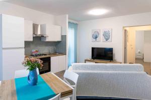 a kitchen and living room with two beds and a table at Casa Turchese in Alghero