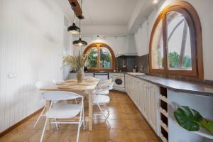 a kitchen with a table and white chairs at Ca la Crish in Horta de San Joan +14 photos