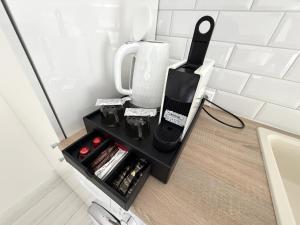 a coffee maker on a shelf in the corner of a kitchen at Cloé Apartman by Noir Hotel in Szeged