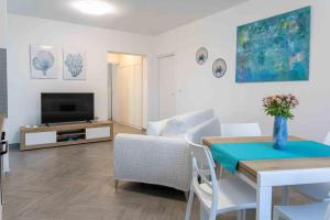 a living room with a table and a television at Casa Turchese in Alghero