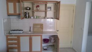 una piccola cucina con armadi in legno e lavandino di Gökmen Apartments a Turunç