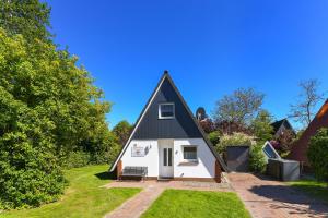 a small house with a black roof at Ferienhaus Windspiel in Neuharlingersiel