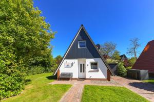 a small house with a black roof at Ferienhaus Windspiel in Neuharlingersiel