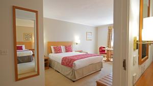 a hotel room with a bed and a mirror at The Hickstead Hotel By Uno-FREE PARKING in Bolney +17 photos