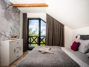 a bedroom with a bed and a large window at Hellene Snow Starý Smokovec in Starý Smokovec