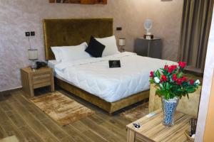 a bedroom with a bed with a vase of flowers at Hotel Cafe Sahariano in Smara