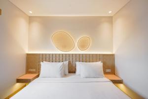a bedroom with a bed with two mirrors on the wall at Kotta Kyu Hotel Semarang in Semarang