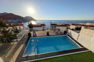 a swimming pool with a view of the ocean at Apartamentos Julio Visconti in San José