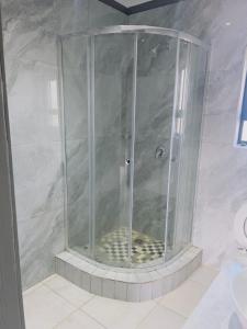 a shower with a glass enclosure in a bathroom at Mangena Legacy Guesthouse in Polokwane