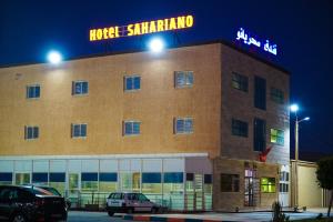 a large building with a neon sign on top of it at Hotel Cafe Sahariano in Smara