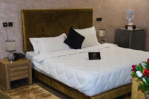 a bedroom with a large bed with white sheets and pillows at Hotel Cafe Sahariano in Smara