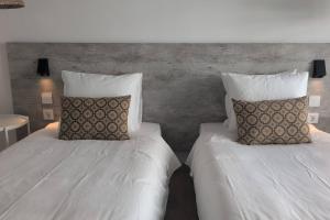 two beds with pillows in a hotel room at RCE Albufeira Spring, Summer & Fall in Albufeira