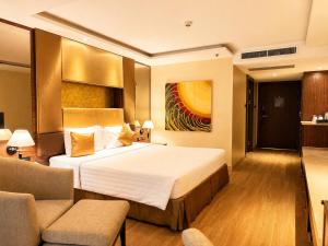 ein Hotelzimmer mit einem Bett und einer Couch in der Unterkunft Nova Gold Hotel Pattaya in Pattaya
