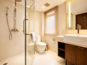 ein Badezimmer mit Toilette, Waschbecken und Dusche in der Unterkunft Nova Gold Hotel Pattaya in Pattaya