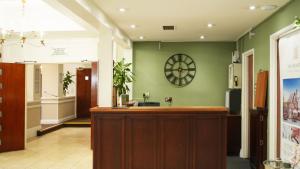 a lobby with a reception desk and a clock on the wall at The Hickstead Hotel By Uno-FREE PARKING in Bolney