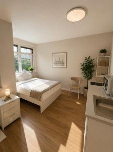 a bedroom with a bed and a kitchen with a sink at Hotel Am Weberplatz in Dresden