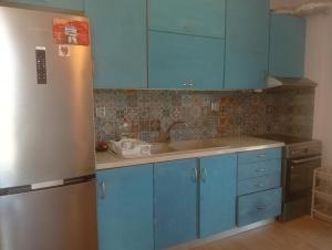 a kitchen with blue cabinets and a stainless steel refrigerator at Evriaki Rooms Lesvos in Apidias Lakos +5 photos