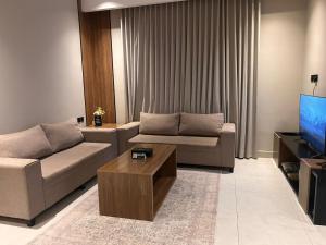 a living room with a couch and a coffee table at هيلز للشقق المخدومة in Hail