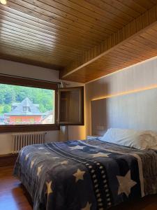 a bedroom with a large bed with a large window at Hotel Europa Les by Dynamic Hotels in Les