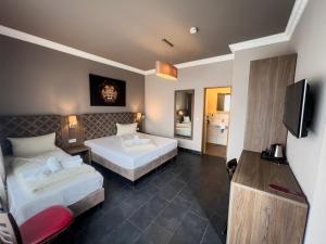 a hotel room with two beds and a television at Hotel Il Cavallino in Warendorf