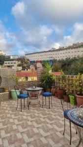 a patio with tables and chairs and a building at Gite El Menzeh in Moulay Idriss