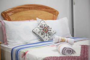 a bed with a wooden headboard and pillows at Gite El Menzeh in Moulay Idriss