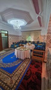 a large room with two tables and a chandelier at Gite El Menzeh in Moulay Idriss