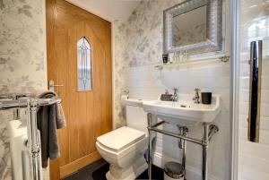 a bathroom with a toilet and a sink at Carnegie Library: Bronte Apartment 1 Bedroom in Swinton