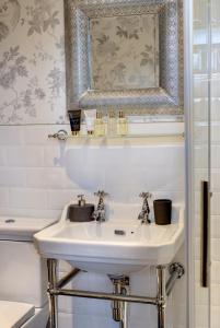 a bathroom with a white sink and a mirror at Carnegie Library: Bronte Apartment 1 Bedroom in Swinton