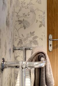 a bathroom with a towel hanging on a wall at Carnegie Library: Bronte Apartment 1 Bedroom in Swinton