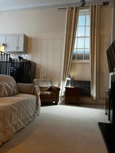 a living room with a couch and a window at Carnegie Library: Bronte Apartment 1 Bedroom in Swinton