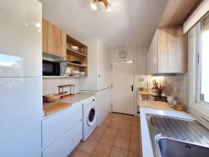 a kitchen with white cabinets and a washer and dryer at Playa de Baria I in Vera