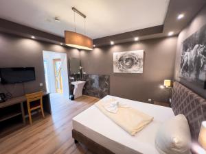 a living room with a bed and a television at Hotel Il Cavallino in Warendorf