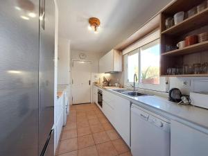 a kitchen with white cabinets and a large window at Playa de Baria I in Vera