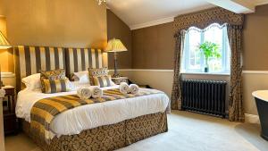 a bedroom with a large bed with towels on it at Bettws Hall Accommodation in Newtown