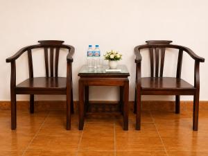 two chairs and a table with bottles of water and flowers at Hisun Hotel Quốc tế - Đông Anh in Thụy Ha