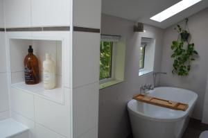 a white bathroom with a toilet and a sink at Cozy Cottage in Schoorl
