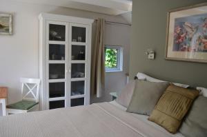a bedroom with a white bed and a window at Cozy Cottage in Schoorl