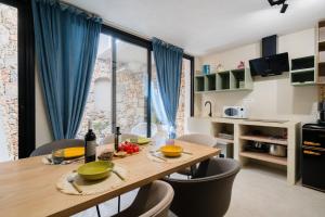 a kitchen with a wooden table with chairs and a dining room at Le Sanpietrane in Taviano