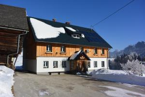 ein großes Holzhaus mit schwarzem Dach in der Unterkunft Ferienwohnung Pöreiterhof in Tauplitz